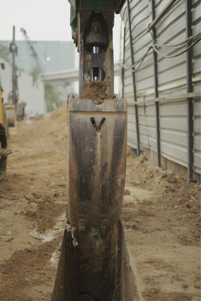 Excavator bucket digging a trench in Gurgaon.